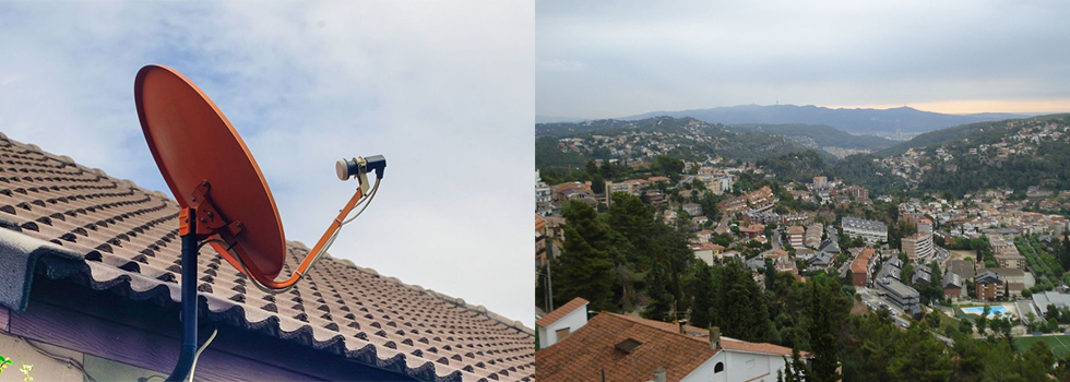 Una antena parabólica de color naranja montada en un tejado, con un paisaje urbano y las colinas circundantes visibles en el fondo.