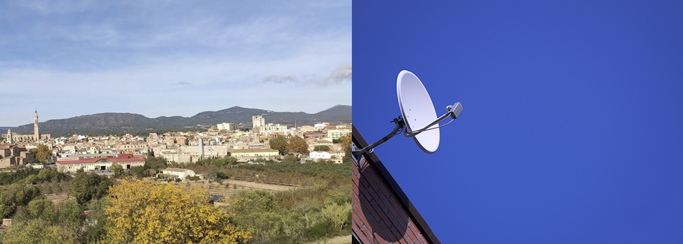 Un paisaje urbano con árboles y edificios a la izquierda; una antena parabólica montada en un tejado contra un cielo azul despejado a la derecha.